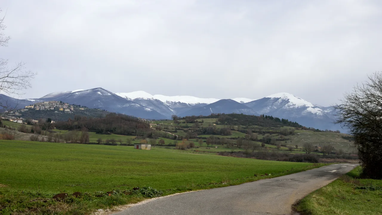 Paesaggio nei dintorni di Trivigliano con campi e montagne innevate