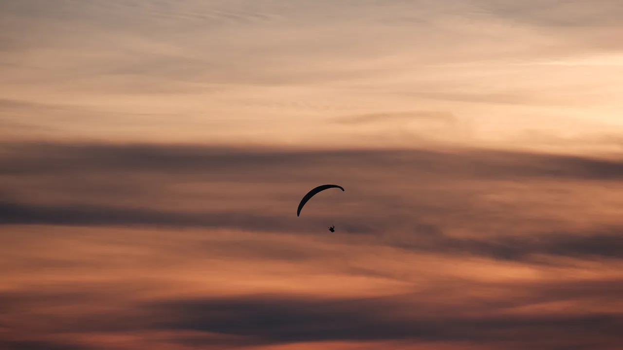 Parapendio in volo nel cielo della sera